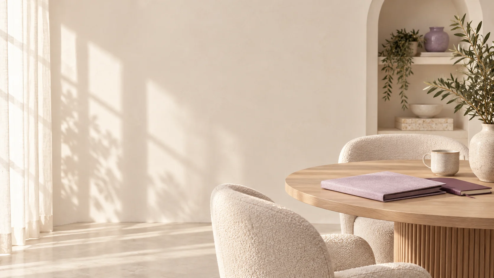 Sunlit cream studio meeting space with lavender proposal folders and olive greenery