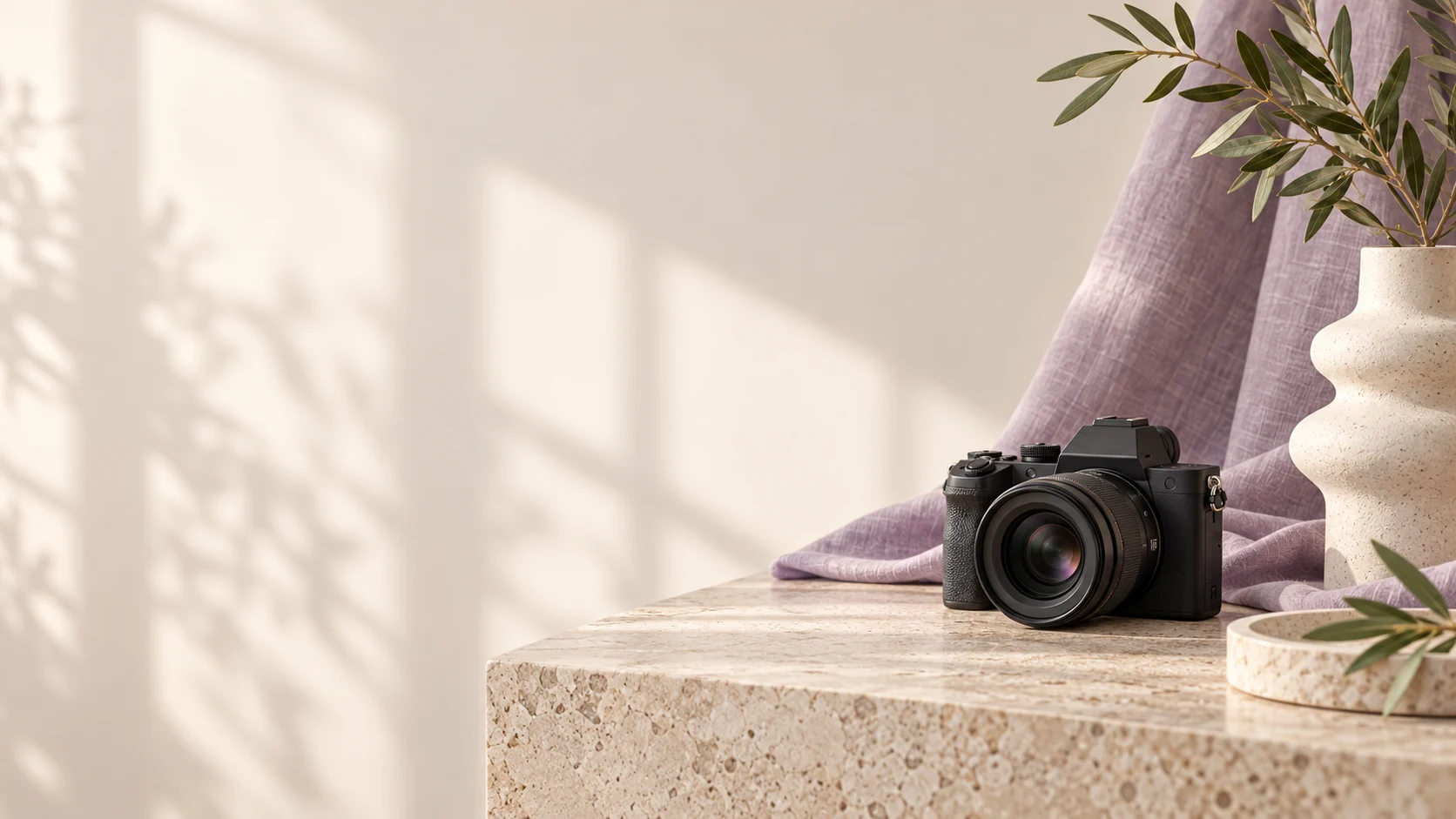 Editorial content photography setup with a camera, lavender linen and olive foliage
